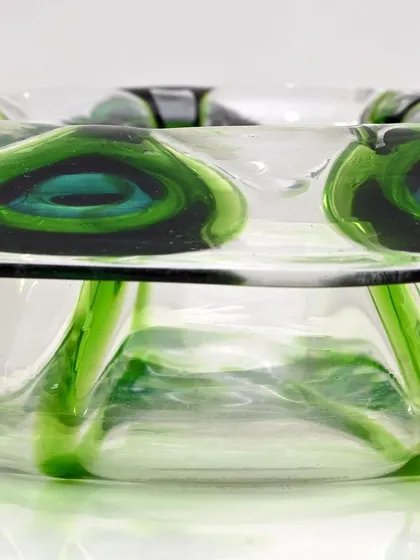 A duplicate side-view of the Bohemian glass bowl, emphasizing the depth of the green peacock feather pattern within the clear glass.