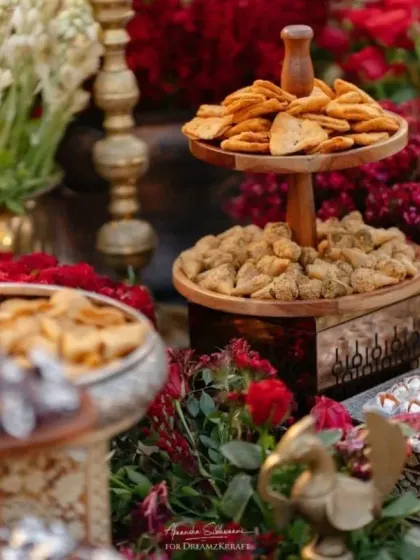 A close-up of the delectable sweet arrangements, showcasing the attention to detail in presentation. The tiered wooden stands and brass bowls complement the traditional, opulent theme.