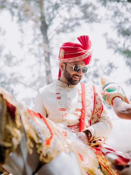 The groom's 'Baraat' arrival on a decorated horse, looking stylish and ready for the ceremony.