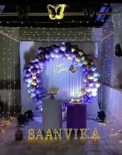 Our butterfly theme creates a magical and whimsical atmosphere. This beautiful terrace canopy setup for Saanvika's birthday features purple and gold balloons, fairy lights, and delicate butterfly accents.