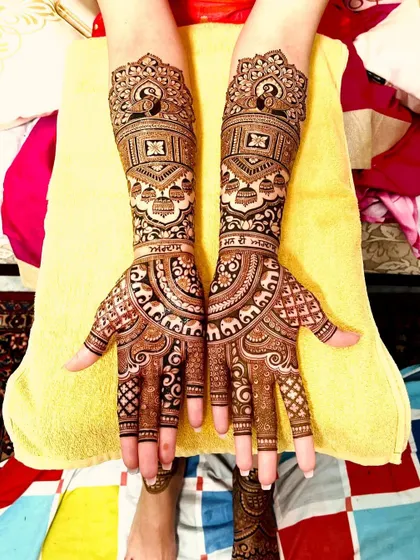 A classic bridal design with intricate details. It features peacocks, elephants, and the bride's name, Simran, written in Punjabi, adding a personal touch.