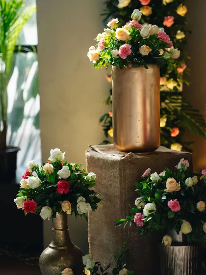 A collection of floral arrangements in different metallic vases.