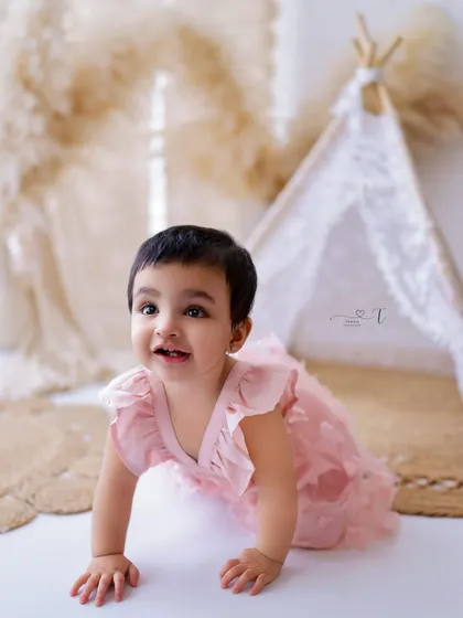 Another angle of this adorable crawler, showing her determination and excitement. The soft pink dress adds a touch of sweetness.