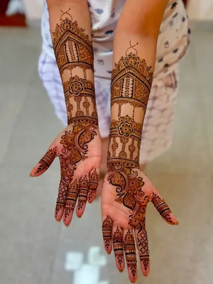 This symmetrical design features architectural tops (gumbad) and delicate floral vines, creating an elegant and balanced look across both arms.