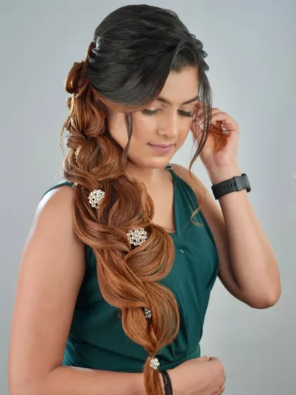 A student's finished work on a live model, showcasing a complex side braid with beautiful volume and texture.