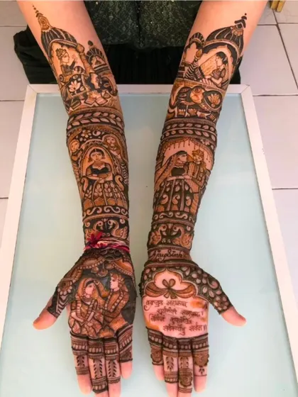 A story-rich design with multiple scenes, including a bride in a doli, a couple portrait, and a message written in Hindi on the palm.