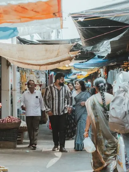 A wide shot capturing the atmosphere of a bustling Indian market during a unique pre-wedding shoot. We love telling stories that reflect your personality.