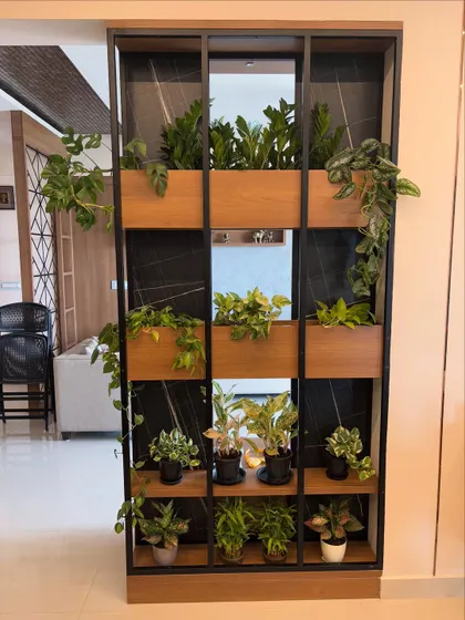 Plants can be beautiful and functional. For this home, I designed a custom metal and wood partition that acts as a living divider. It separates the space while keeping it open and airy, filled with a variety of easy-care indoor plants that clean the air.