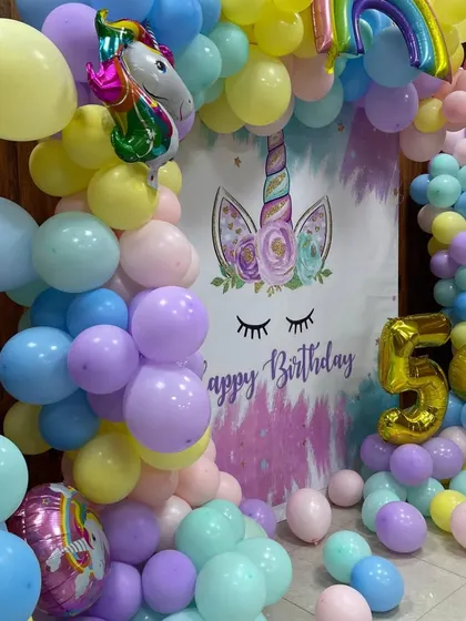 A close-up of the unicorn balloon arch, showing the detail of the different balloon sizes and the cute unicorn foil balloons.