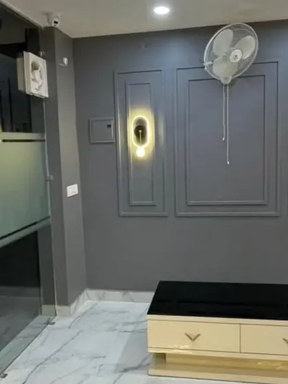 The waiting area in the same Lucknow office. The grey paneled wall with modern sconce lights provides a sophisticated backdrop, showing how to create impact even in a small area.