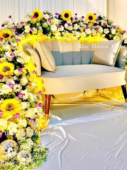 I love creating unique focal points for your events. This floral couch for a Roka ceremony is a great example, where the seating itself becomes a work of art, enveloped in an arch of sunflowers, daisies, and other beautiful artificial blooms.