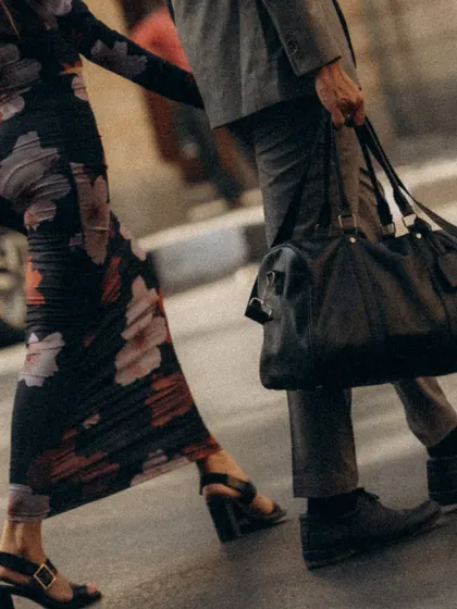 A detail shot focusing on their movement. The close up on their legs, his bag, and their linked hands tells a story of a journey taken together.