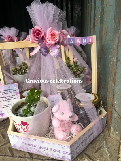 Pretty in lilac for a baby girl's celebration. This hamper features a butterfly theme with a customized planter, a pink teddy bear candle, and jars of treats.
