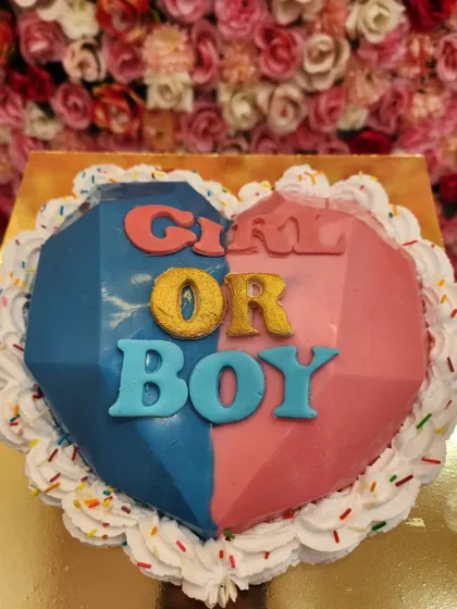 A piñata cake designed for a gender reveal party. The "Girl or Boy" theme is split between pink and blue, and the inside holds the big secret.