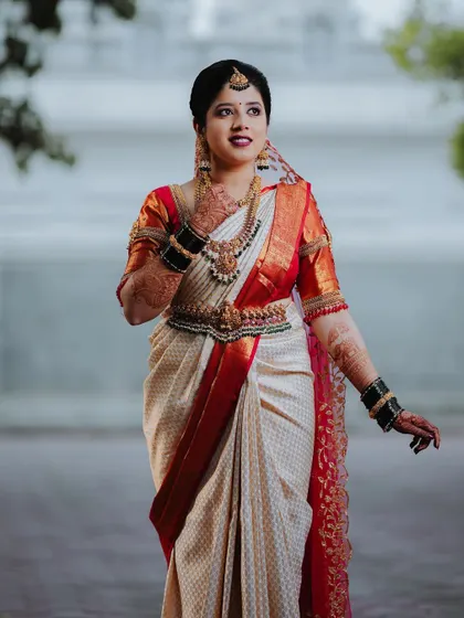 A classic portrait of the bride in her beautiful white and red wedding saree.