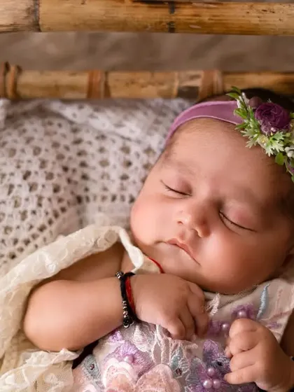 A sweet sleeping baby girl in a beautiful lace outfit. The soft textures and peaceful expression make this a truly precious portrait.