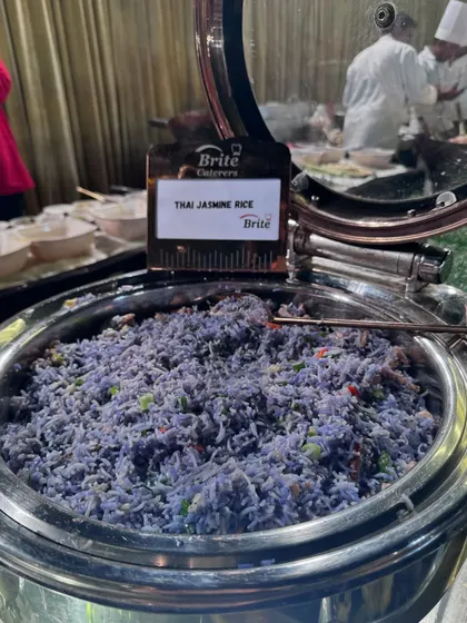 A unique offering of Thai Jasmine Rice, naturally colored blue, served in a polished steel chafing dish.