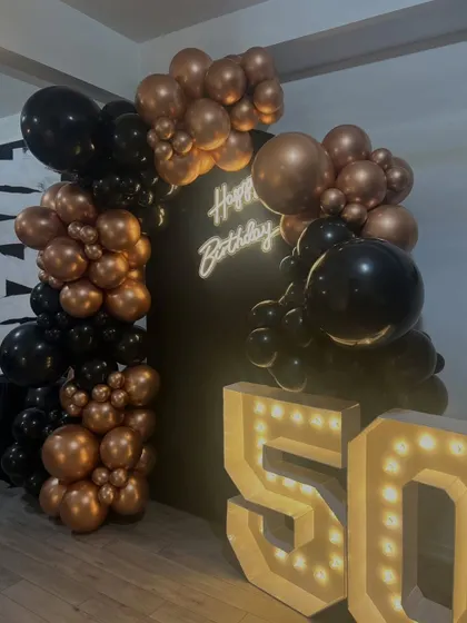 The decor is designed to look great from every angle. This side view shows the depth of the balloon garland and how the marquee numbers provide a strong visual anchor for the entire installation.