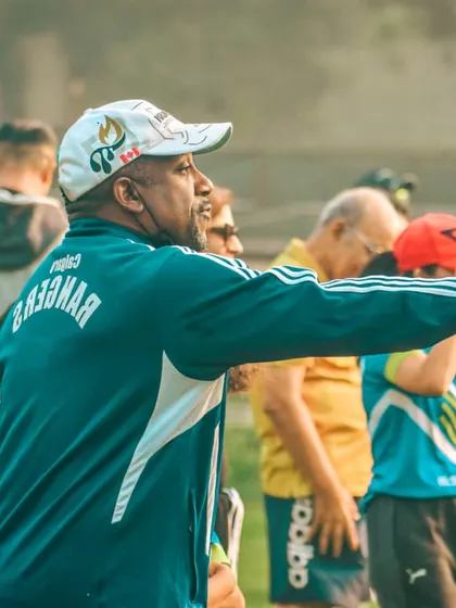 A coach directs his players from the sideline, fully engaged in the game.