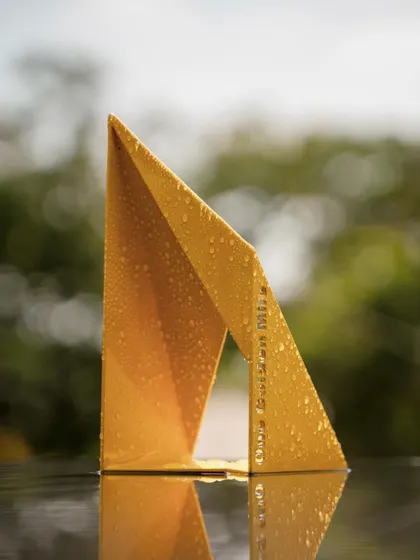A close-up of the "Yello" model, showing the crispness of its folded form. Even at a small scale, the sculpture's powerful geometry and bold color are evident. This process of prototyping is crucial to our design development.