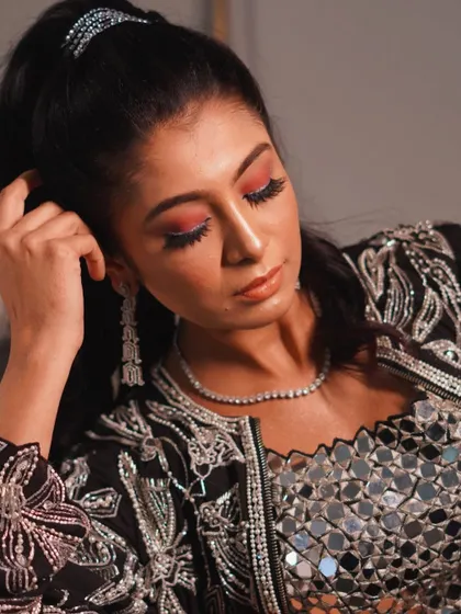 This look is for someone who loves a pop of color. The vibrant coral eyeshadow is the star of the show, balanced with glowing skin and a neutral lip. It's a fun and trendy look for a sangeet or cocktail party.