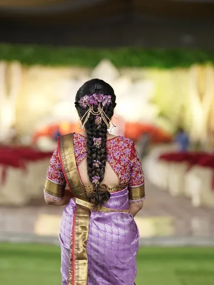 A back view of the bride, showing how the blouse complements her traditional hairstyle and saree.