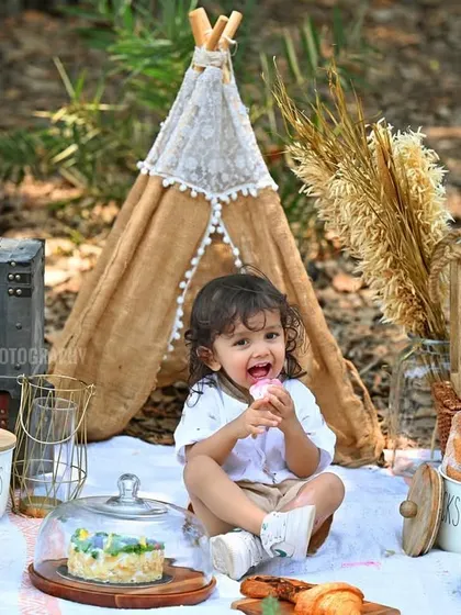A fun picnic-themed kid's photoshoot, with the little one enjoying some treats in a beautiful outdoor setting.