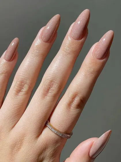 A full view of this stunning nude glitter manicure. The long, elegant shape of the nails combined with the sophisticated sparkle makes this a perfect choice for a bride who wants a glamorous yet understated look.