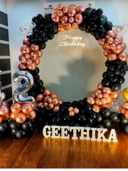 A stylish 42nd birthday celebration with a black and rose gold balloon ring, perfect for a chic and modern party at home.