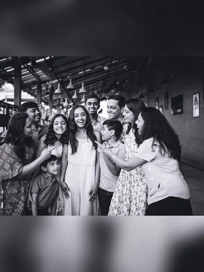 A playful black and white group photo where the whole family is focused on one person. These fun, interactive shots show the family's personality.