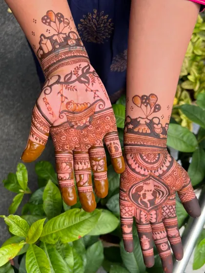 The full view of this storytelling baby shower mehendi, with one palm showing a baby in a cradle and the other a mother silhouette.