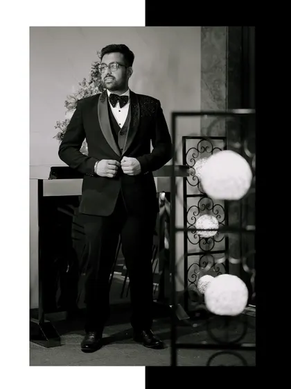 A timeless black and white portrait of the groom, capturing a moment of quiet confidence.