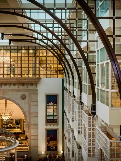 A "sneak peek" from a high vantage point. This architectural shot frames the couple in a window, showing the grandeur of the hotel venue.