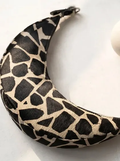 A close-up of the Selena in a classic two-tone cattle print. The hair-on leather provides a unique texture, making it a standout piece that is still neutral enough for everyday wear.