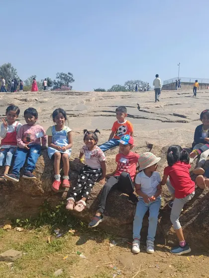 The children take a rest on the iconic rock formations of Lalbagh. This natural playground offers endless opportunities for climbing and exploration.