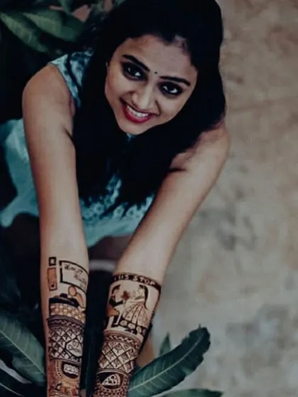 A top-down view of Rashmi's storytelling mehendi, showing all the custom elements like her love for pizza and the #NiRa hashtag.