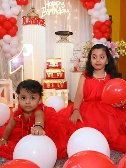A classic and sweet red and white themed first birthday, with the birthday girl and her sister playing amongst the balloons and 'BABY' blocks.