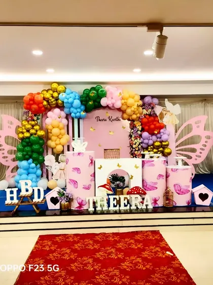 A colourful butterfly theme for Theera's first birthday. We used a vibrant mix of balloons, large pink butterfly wings, and themed pedestals to create a cheerful and eye-catching stage.