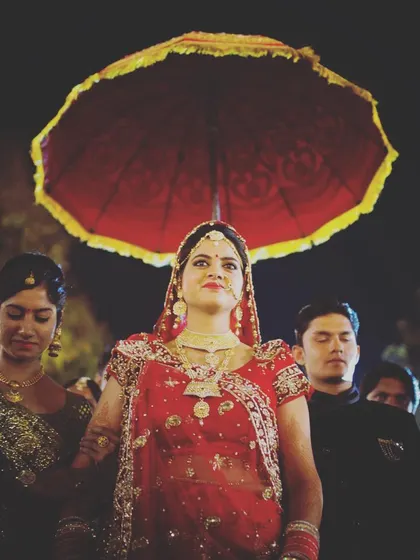 The bride's entrance is a grand and regal moment. I captured her entry under a traditional umbrella, using the lighting to create a majestic feel that highlights her poise and the significance of the ceremony.
