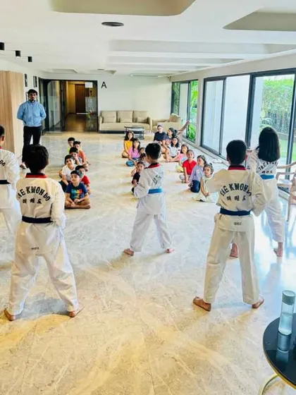 A view from the back of the class, showing students practicing in front of their parents.