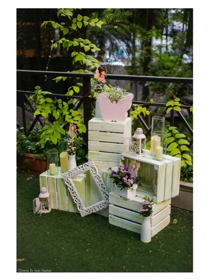 Rustic crates adorned with flowers, lanterns, and butterfly cutouts. These decorative elements are perfect for adding a touch of enchanted forest charm to any corner of the party.
