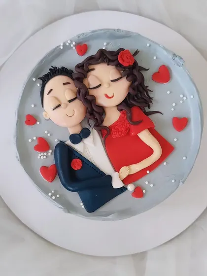 A lovely hand-painted cake celebrating love. This design features a custom portrait of a couple, surrounded by little red hearts, perfect for an anniversary or Valentine's Day.