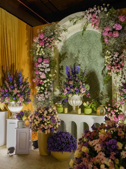 A close-up of a floral archway, showcasing the rich mix of pink, purple, and white flowers. The abundance and variety of blooms create a stunning visual impact.