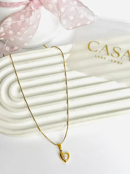This heart and pearl pendant necklace is presented in a clean, minimalist style. This is a classic product shot, perfect for website listings and online marketplaces.