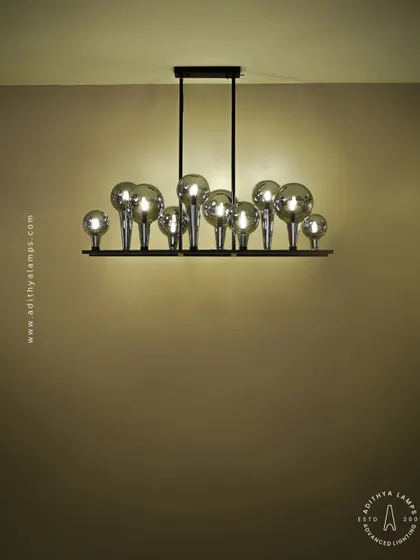 A playful yet chic linear chandelier featuring a series of chrome-finished glass bubbles. The highly reflective surface and modern design make it a striking addition to a kitchen island or a contemporary dining space.