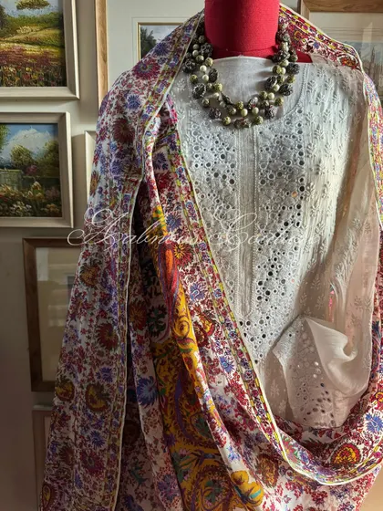 We present another fusion ensemble, pairing a Chikankari suit featuring intricate mirrorwork with a vibrant Kashmiri Kalamkari dupatta. This image shows the full, draped look on a mannequin.