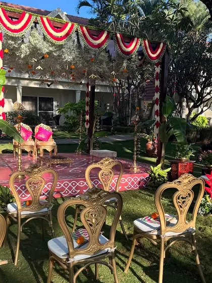 A closer view of a traditional Brahmin wedding mandap, showcasing the ornate chairs and festive decor under the bright sun.