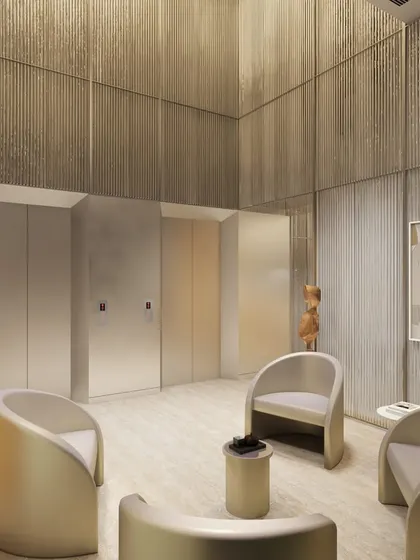 An elevator lobby with gracefully curved seating and textured, fluted walls. This transitional space is designed with the same attention to detail and material quality as the primary workspaces, ensuring a cohesive design experience.