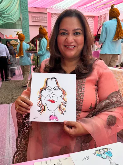 This guest looks pleased with her caricature, a lovely souvenir from a beautifully decorated wedding event.