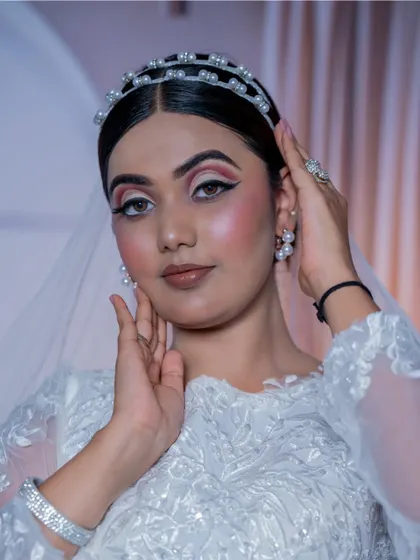 A close-up of the Christian bridal makeup. The pearl headband and earrings add a touch of elegance, and the makeup is kept fresh and luminous to match.